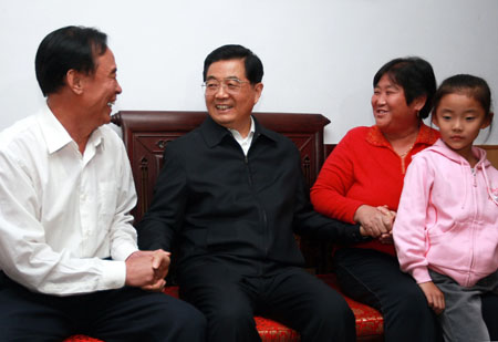 Chinese President Hu Jintao (2nd L), who is also general secretary of the Central Committee of the Communist Party of China and chairman of the Central Military Commission, visits Yang Changju's home in Zhangdian District, Zibo City of east China's Shandong Province, Oct. 17, 2009. [Ju Peng/Xinhua]