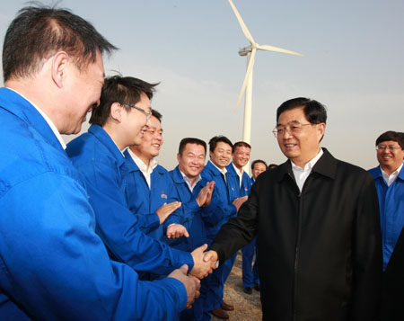 Chinese President Hu Jintao (2nd R), who is also general secretary of the Central Committee of the Communist Party of China and chairman of the Central Military Commission, shakes hands with workers as he inspects a wind power project in east China's Shandong Province, Oct. 18, 2009. [Ju Peng/Xinhua]