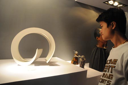 A visitor views exhibits at the exhibition hall of 2009 China Jingdezhen International Ceramic Fair in Jingdezhen, east China's Jiangxi Province, Oct. 18, 2009. The 2009 China Jingdezhen International Ceramic Fair kicked off here on Oct. 18. [Shi Weiming/Xinhua]