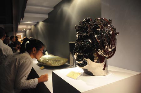 A visitor views exhibits at the exhibition hall of 2009 China Jingdezhen International Ceramic Fair in Jingdezhen, east China's Jiangxi Province, Oct. 18, 2009. The 2009 China Jingdezhen International Ceramic Fair kicked off here on Oct. 18. [Shi Weiming/Xinhua]