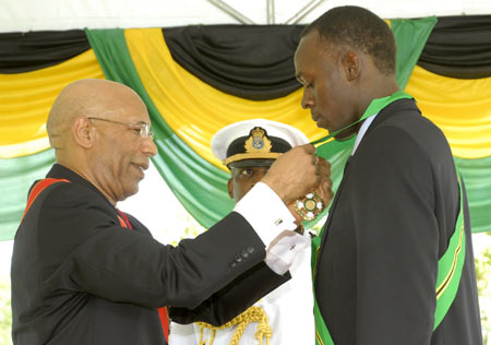 Triple Olympic and world champion sprinter Usain Bolt (R) receives the Order of Jamaica from Jamaica's Governor General Patrick Allen during Jamaica's annual National Honours and Awards ceremony in Kingston, October 19, 2009. The Order of Jamaica is Jamaica's fourth highest national honour, and at 23 years old, Bolt is the youngest Jamaican to receive the award. [Xinhua/Reuters]