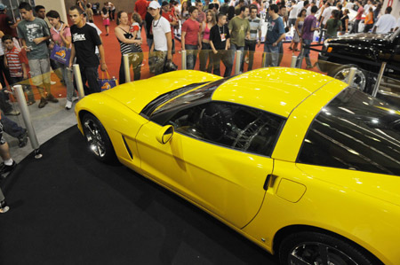 Visitors look at a Ferrari sports car at the 5th Sports Cars Exhibition in Sao Paulo, Brazil, Oct. 18, 2009. Started from last Thursday, the four-day exibition shows various cars with modifications which has attracts more than 70 thousands visitors. [Song Weiwei/Xinhua]