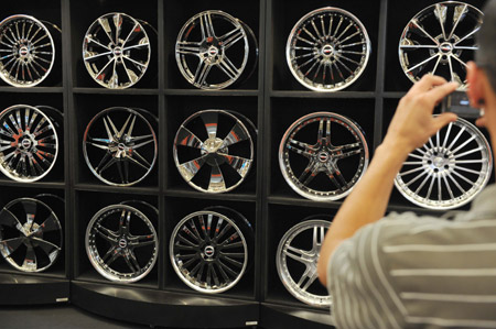 A visitor take photos for wheels with different styles at the 5th Sports Cars Exhibition in Sao Paulo, Brazil, Oct. 18, 2009. [Song Weiwei/Xinhua]