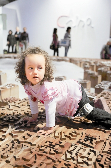 A girl climbs over a Chinese movable type exhibit during the 61st Frankfurt Book Fair on Saturday. 