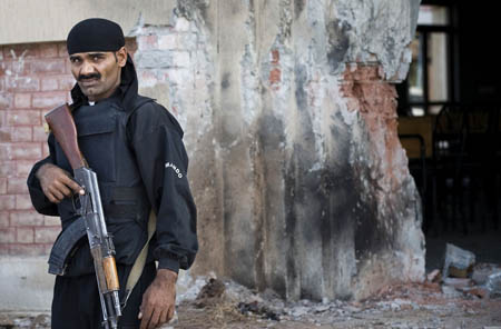 A Pakistani policeman stands guard at the site of the bomb blast at Islamabad's Islamic International University on Oct. 20, 2009.[Xinhua/AFP]