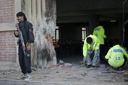 Pakistani police bomb squad officials investigate at the site of the bomb blast at Islamabad's Islamic International University on Oct. 20, 2009. Two blasts occurred in a university in Pakistan's capital city of Islamabad Tuesday, leaving at least four people dead and 16 others injured, local TV channel reported.[Xinhua/AFP]