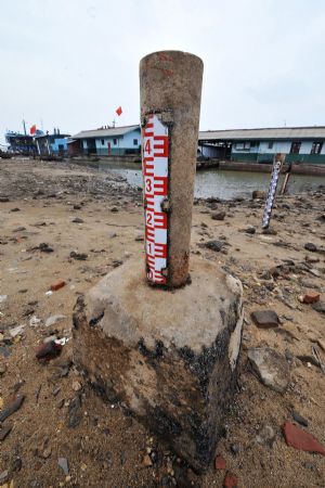 Photo taken on Oct. 20, 2009 shows the pole which is used to measure the water level of the Xiangjiang River is completely unveiled in Changsha, capital of central China's Hunan Province. Sustained drought along the Xiangjiang River has caused a severe shortage of drinking water for more than 3 million people in the cities of Changsha, Zhuzhou and Xiangtan.[Xinhua]