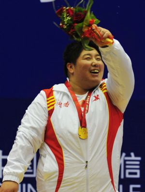 Qi Xihui of Hunan waves to the audience during the awarding ceremony for the women's weightlifting over 75kg division in the 11th Chinese National Games in Jinan, east China's Shandong Province, Oct. 20, 2009. Qi won the gold medal with a total of 324kg. [Xinhua]