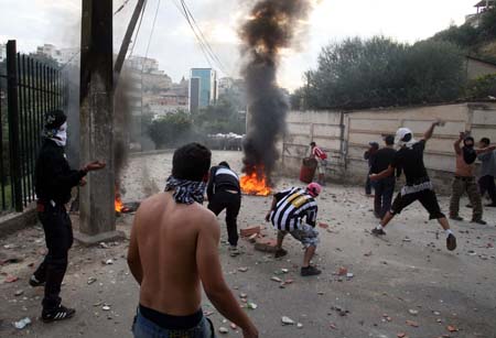 Protesters throw stones to riot police during clashes at Diar Echams district in Algeries, capital of Algeria, Oct. 20, 2009. [Xinhua]