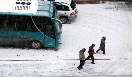 Local residents walk in the snow on the road in Hexigten Banner, north China's Inner Mongolia Region, Oct. 20, 2009. A snowfall hit the area on Tuesday. [Xinhua]