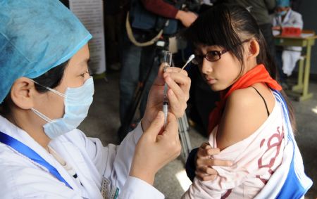 A student receives A/H1N1 flu vaccine injection at Chuiyangliu middle school in Beijing, capital of China, Oct. 21, 2009. China started a nationwide vaccine program to counter the A/H1N1 virus on Wednesday, beginning with frontier health workers and those in at-risk groups.