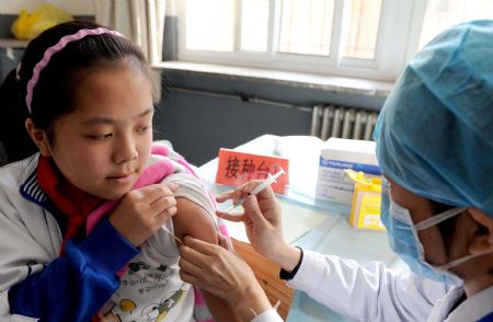 A student receives A/H1N1 flu vaccine injection at Chuiyangliu middle school in Beijing, capital of China, Oct. 21, 2009. Beijing started Wednesday inoculating students, medical staff, public servants and elderly people with A/H1N1 flu vaccine free of charge[Xinhua]
