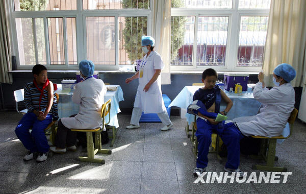 Students receive an H1N1 vaccine injection at a middle school in Beijing October 21, 2009. Beijing started Wednesday inoculating students, medical staff, public servants and elderly people with A/H1N1 flu vaccine free of charge, a local disease control and prevention official said. [Xinhua]
