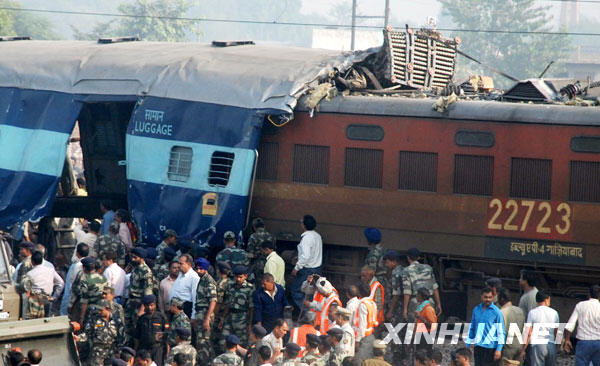 Indian Railway Protection Force (RPF) personnel look at two trains that collided on the same track near Mathura, south-east of New Delhi. A Delhi-bound Indian express train ploughed into the back of another near the Taj Mahal town of Agra early Wednesday, police said.[Xinhua]