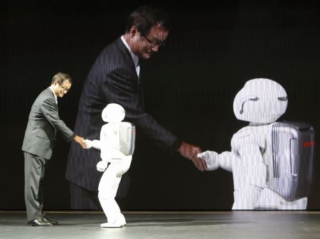 Honda Motor Co Chief Executive Officer Takanobu Ito shakes hands with an Asimo humanoid robot during a Honda presentation at the 41st Tokyo Motor Show in Chiba, east of Tokyo, October 21, 2009.[Xinhua/Reuters]