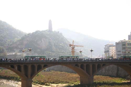 With haze blurring Pagoda Hill in the background, traffic crosses a bridge in downtown Yan'an, Shaanxi Province, on Wednesday, October 21, 2009. [CRI] 