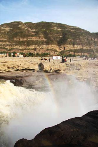 A rainbow hovers over the mists above Hukou Waterfall along the Yellow River east of Yan'an, Shaanxi Province, on Wednesday, October 21, 2009. [CRI] 