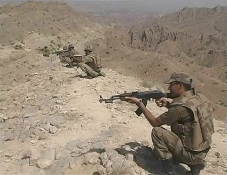 Pakistani soldiers point their weapons during a battle between Pakistani security forces and Taliban in the South Waziristan region in this image taken from a video grab released by the Pakistani military on October 21, 2009. Pakistani forces launched an offensive to wrest control of the lawless South Waziristan region on October 17, 2009 after militants rocked the country with a string of bomb and suicide attacks in recent weeks.(Xinhua/Reuters Photo)