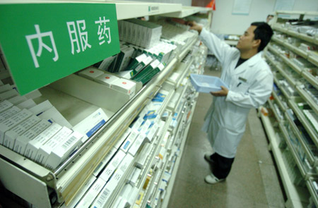 An apothecary takes medicines for patients in the provincial hospital in Hefei, east China's Anhui Province, Oct. 22, 2009. The guiding retail price for basic medications publicized by the National Development and Reform Commission (NDRC) was implemented in the country as of Thursday. [Xinhua]