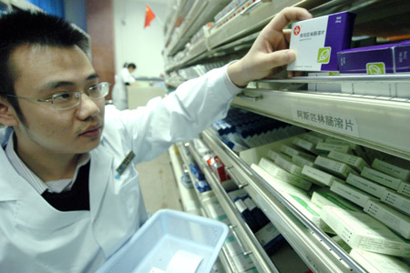 An apothecary takes medicines for patients in the provincial hospital in Hefei, east China's Anhui Province, Oct. 22, 2009. [Xinhua]
