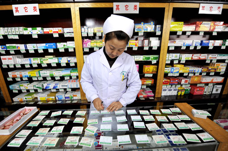 A woman updates the price of medicine in a drug store in Yinchuan, northwest China's Ningxia Hui Autonomous Region, Oct. 22, 2009. [Xinhua]