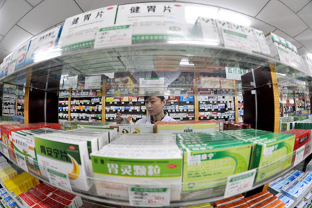 A woman put medicine on the shelf in a drug store in Yinchuan, northwest China's Ningxia Hui Autonomous Region, Oct. 22, 2009. [Xinhua]
