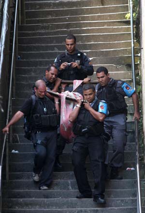 Police officers carry a body down a stairway from Morro Santo Amaro slum where a shootout took place about an hour earlier in Rio de Janeiro Oct. 21, 2009. Seven people were killed in clashes between drug dealers and police here on Wednesday, local authorities said.[Xinhua/Reuters]