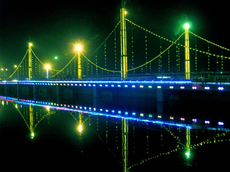 Photo taken on Oct. 15, 2009 shows the night scene of the Konqi River Bridge in Korla, capital of Mongolian Autonomous Prefecture of Bayingolin, northwest China's Xinjiang Uygur Autonomous Region. Located on the northeast edge of the Tarim Basin, Korla is known for its production of fragrant pears, oil and natural gas. [Xinhua]