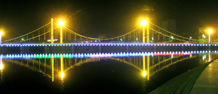 Photo taken on Oct. 15, 2009 shows the night scene of the Konqi River Bridge in Korla, capital of Mongolian Autonomous Prefecture of Bayingolin, northwest China's Xinjiang Uygur Autonomous Region. Located on the northeast edge of the Tarim Basin, Korla is known for its production of fragrant pears, oil and natural gas. [Xinhua]