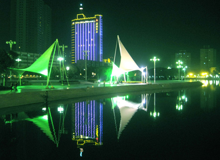 Photo taken on Oct. 15, 2009 shows the night scene of the Konqi River in Korla, capital of Mongolian Autonomous Prefecture of Bayingolin, northwest China's Xinjiang Uygur Autonomous Region. Located on the northeast edge of the Tarim Basin, Korla is known for its production of fragrant pears, oil and natural gas. [Xinhua]