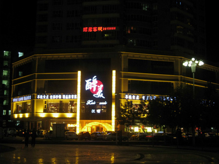 Photo taken on Oct. 15, 2009 shows buildings along a street in Korla, capital of Mongolian Autonomous Prefecture of Bayingolin, northwest China's Xinjiang Uygur Autonomous Region. Located on the northeast edge of the Tarim Basin, Korla is known for its production of fragrant pears, oil and natural gas. [Xinhua]