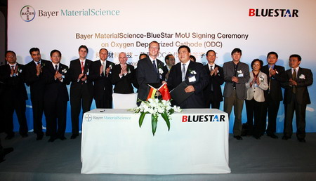 Michael Koenig (L, Front), president of Bayer Greater China Groups, and Bai Xinping (R, Front), general manager of China National BlueStar, sign a memorandum of understanding in Beijing, Oct 22, 2009. [China Daily] 