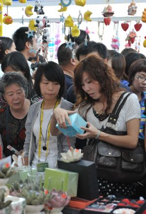 Visitors choose ornaments of Thailand at the Nanning International Convention and Exhibition Center, which is the venue of the 6th China-ASEAN Expo, in Nanning, capital of southwest China's Guangxi Zhuang Autonomous Region, Oct. 24, 2009. The exhibitian hall opened to public on Saturday, the last day of the five-day expo. [Zhou Hua/Xinhua]