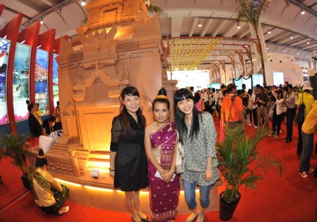 Local residents pose for photos with an actor at Laos Pavilion in the Nanning International Convention and Exhibition Center, which is the venue of the 6th China-ASEAN Expo, in Nanning, capital of southwest China's Guangxi Zhuang Autonomous Region, Oct. 24, 2009. The exhibitian hall opened to public on Saturday, the last day of the five-day expo. [Zhou Hua/Xinhua]