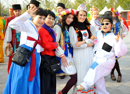 Performers from different countries and regions pose for a group photo before the performance at the Olympic Park in Beijing, capital of China, on Oct. 23, 2009. [Luo Xiaoguang/Xinhua] 