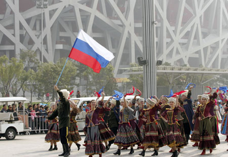 Performers from Russia wave to visitors during a parade at the Olympic Park in Beijing, capital of China, on Oct. 23, 2009. [Shi Sisi/Xinhua] 