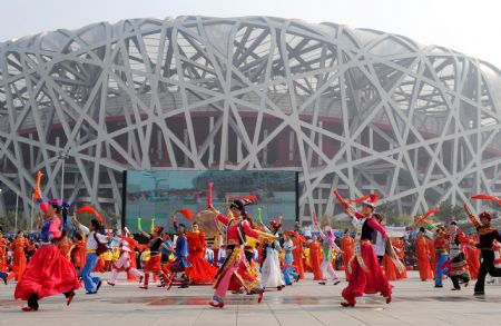  Performers dance during a parade at the Olympic Park in Beijing, capital of China, on Oct. 23, 2009. [Xinhua]