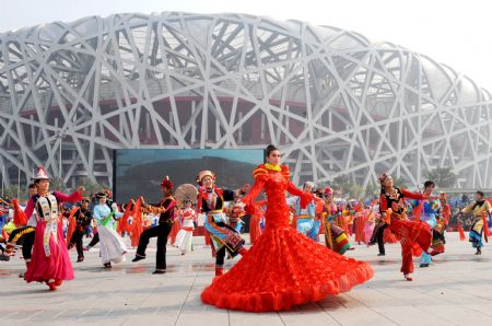  Performers dance during a parade at the Olympic Park in Beijing, capital of China, on Oct. 23, 2009. [Xinhua]