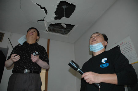 Staff members of the Chinese embassy in Iraq check a ceiling after a car bomb explosion in Baghdad, capital of Iraq, Oct. 25, 2009. (Xinhua/Gao Shan)