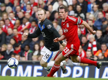 Liverpool's Jamie Carragher (R) challenges Manchester United's Wayne Rooney (L) during their English Premier League soccer match at Anfield in Liverpool, northern England, October 25, 2009.(Xinhua/Reuters Photo) 