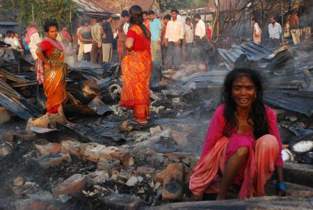 A slum dweller sits amid the debris of her burnt shanty in the eastern Indian city of Siliguri, October 25, 2009. More than one thousand people evacuated after a fire swept through the slum area and the cause of the fire is still unknown, a fire official said on Sunday.