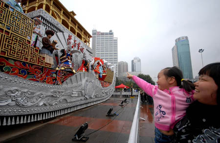 Local citizens swarm to watch in close range the Colorful Guizhou Float, which took part in the grand parade in celebration of the 60th anniversary of the founding of the Peoples' Republic of China on the Tian'anmen Square in Beijing, during its presentation on the People's Square of Guiyang, southwest China's Guizhou Province, Oct. 25, 2009. (Xinhua/Cheng Jie)