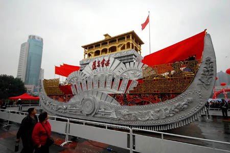 Local citizens admire in close range the Colorful Guizhou Float, which took part in the grand parade in celebration of the 60th anniversary of the founding of the Peoples' Republic of China on the Tian'anmen Square in Beijing, during its presentation on the People's Square of Guiyang, southwest China's Guizhou Province, Oct. 25, 2009. (Xinhua/Cheng Jie) 