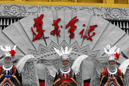 A tripet of female performers in the florid silver costume of Miao ethnic group turns up during the presentation of the Colorful Guizhou Float, which took part in the grand parade in celebration of the 60th anniversary of the founding of the Peoples' Republic of China on the Tian'anmen Square in Beijing, to Guiyang's local citizens on the People's Square of Guiyang, southwest China's Guizhou Province, Oct. 25, 2009. (Xinhua/Ouyang Changpei)