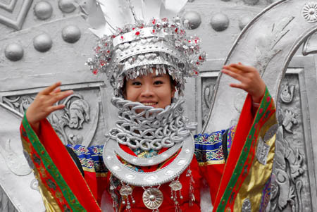 A female performer in the florid silver costume of Miao ethnic group turns up during the presentation of the Colorful Guizhou Float, which took part in the grand parade in celebration of the 60th anniversary of the founding of the Peoples' Republic of China on the Tian'anmen Square in Beijing, to Guiyang's local citizens on the People's Square of Guiyang, southwest China's Guizhou Province, Oct. 25, 2009. (Xinhua/Ouyang Changpei)