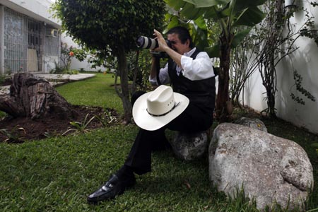 Honduras' ousted President Manuel Zelaya uses a news photographer's camera to take pictures of his family at the Brazilian embassy in Tegucigalpa October 25, 2009. 