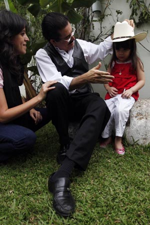 Honduras' ousted President Manuel Zelaya puts his hat on his granddaughter Irene Melara's head as his daughter Xiomara Zelaya (L) sits next to them during a visit at the Brazilian embassy in Tegucigalpa October 25, 2009. 