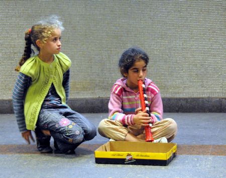 Helin Aslan (R), an eight-year-old girl, begs for money at the Levent Metro Station in Istanbul, the largest city of Turkey, Oct. 25, 2009. (Xinhua/Chen Ming)