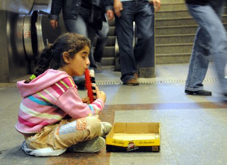 Helin Aslan, an eight-year-old girl, begs for money at the Levent Metro Station in Istanbul, the largest city of Turkey, Oct. 25, 2009. (Xinhua/Chen Ming)