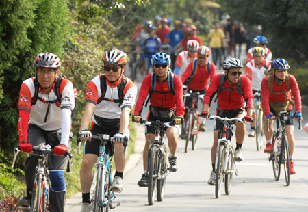 A group of excursionists ride bicycle along the highway inside the scenic zone, during a 2-day Tabernacle Fair, in the Zhuyuwan Scenery Resort, in Yangzhou, east China's Jiangsu Province, Oct. 24, 2009. People enjoy the outdoor activities ranging from photographing, camping, riding, to rock-climbing. etc, to relax their mood by enjoying the idyllic autumn scenery. (Xinhua/Zhao Jun)